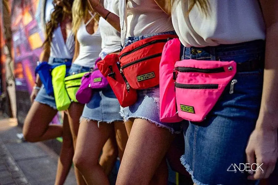 Group of women wearing colorful customizable FezPak fanny packs with detachable bottle holders on city street