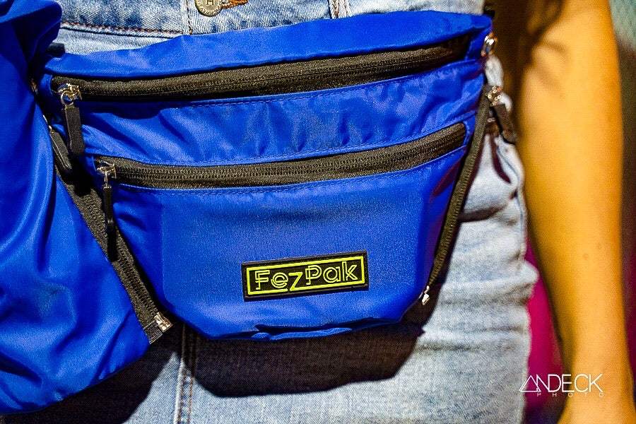 Blue FezPak customizable flat design fanny pack with detachable bottle holder and multiple zip pockets worn on denim shorts