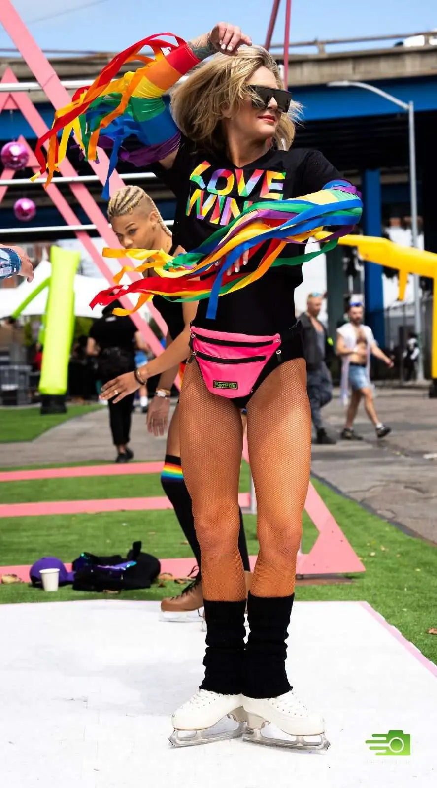 Woman wearing colorful FezPak customizable fanny pack with detachable bottle holder at outdoor event